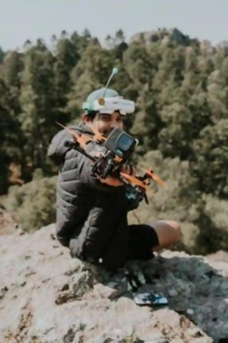 Pria Tersenyum Duduk Dengan Drone Di Atas Batu