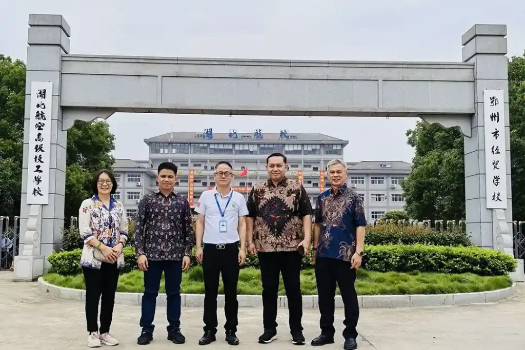 Liu Purnomo and Agung "Sharky" Sasongkojati from PT Remote Pilot Indonesia pose for a group photo with the founder and principal of a drone training school in Wuhan, China, marking a visit focused on strengthening international collaboration in drone education.