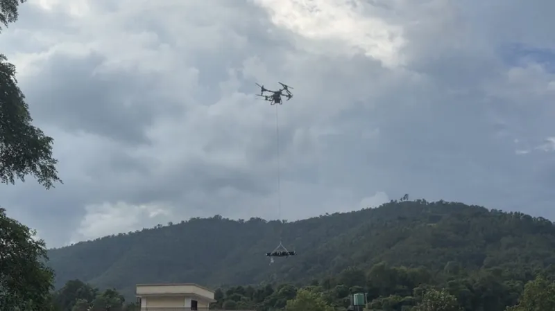 Heavy-lift drone flying over flood-damaged terrain during a rescue operation